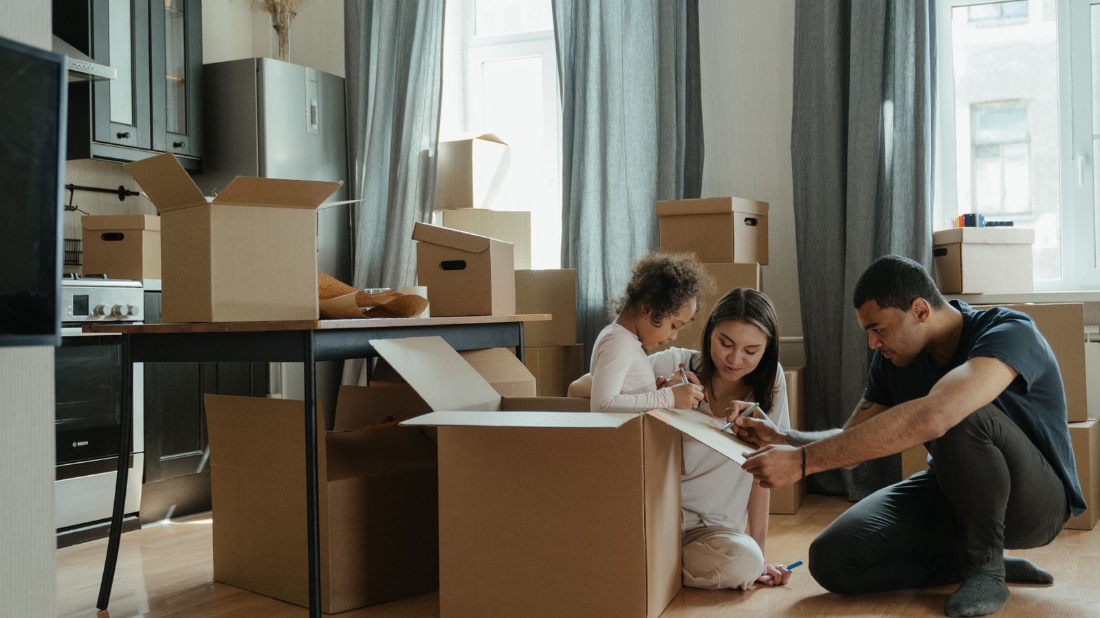 Family unpacking boxes after moving into a new home