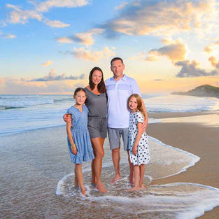 Beach portrait of family of four with stunning lighting.
