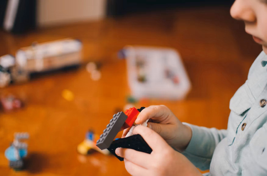 Child playing Lego blocks in pajamas at afterschool program in Hoboken