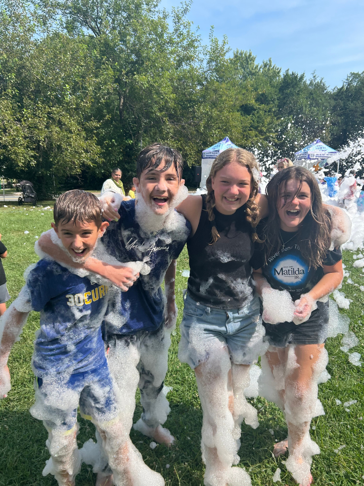 Teens covered in foam during a summer fun event for youth at St. Matthew's in Sterling.