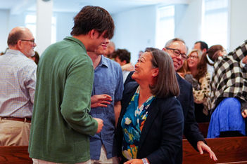 Mother and son smile and talk during fellowship time after Mother’s Day worship service.