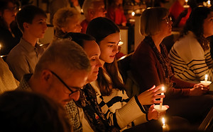 Family and congregation holding candles during the Christmas Eve candlelight service at St. Matthew’s Episcopal Church in Sterling, VA.