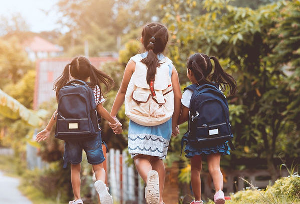 Girls walking down the street wearing backpacks