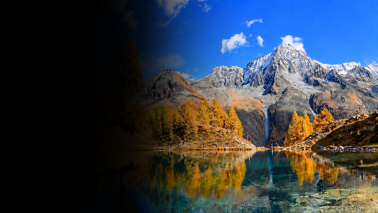 Lac alpin doré sous les sommets enneigés.png