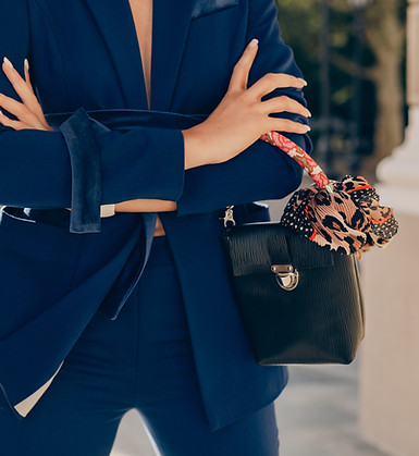 Femme en costume bleu, bras croisés, sac à main