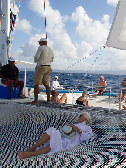 Passengers relaxing on a sailing catamaran deck at sea