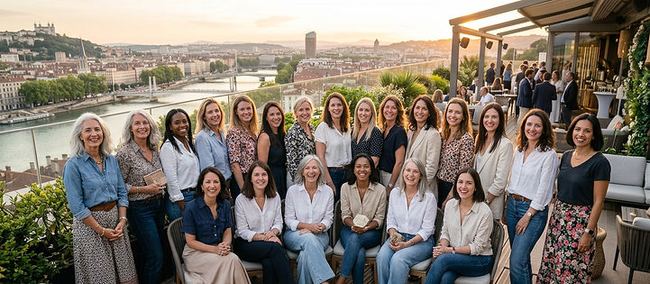 Groupe de femmes souriantes sur un rooftop à Lyon au coucher du soleil.