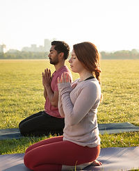 vue-laterale-d-un-homme-et-d-une-femme-meditant-a-l-exterieur-sur-des-tapis-de-yoga.jpg