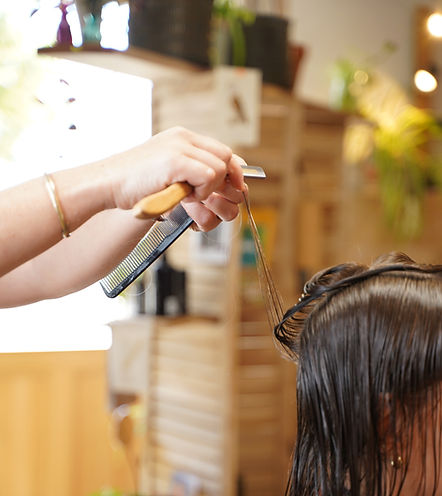 Coiffeuse réalisant une coupe énergétique au rasoir