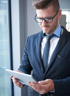 Homme en costume tenant une tablette
