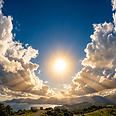 Soleil radieux perçant les nuages au-dessus d'un paysage côtier