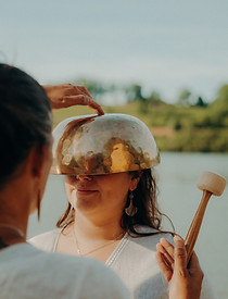 Séance de sonothérapie: bol chantant sur la tête près de l'eau.