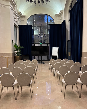 Salle de conférence avec rangées de chaises et écran