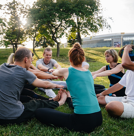 un-groupe-de-personnes-font-du-yoga-en-cercle-en-plein-air-pendant-le-coucher-du-soleil.jp