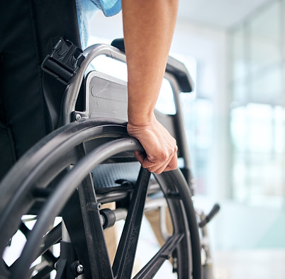 Main saisissant la roue d'un fauteuil roulant