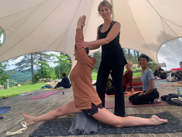 Professeure guidant un étirement de yoga lors d'un atelier.