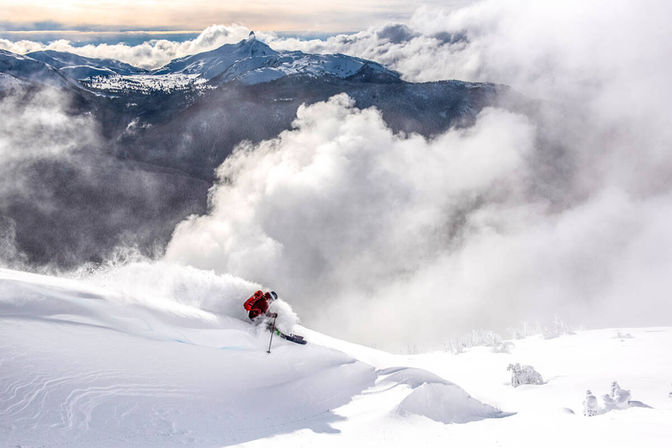 Un homme qui fait du ski devant un n uage de neige