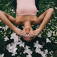 Femme sereine allongée dans l'herbe parmi des fleurs blanches