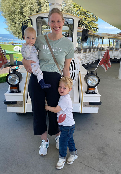 Femme avec deux jeunes enfants devant un petit train
