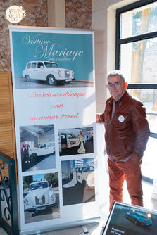 Homme devant une bannière de location de voiture de mariage
