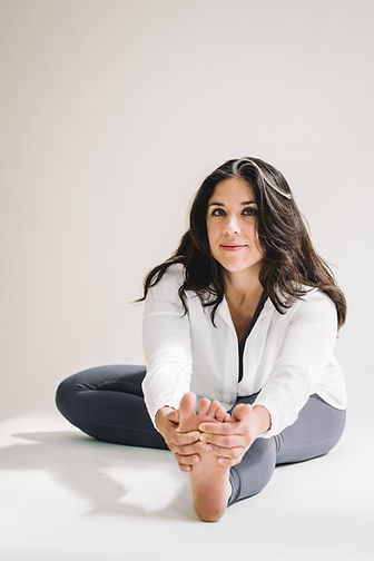 Femme en posture yoga assise, regard calme.