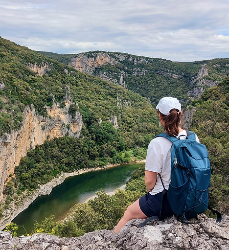 Randonneur contemplant une rivière au fond d'un canyon
