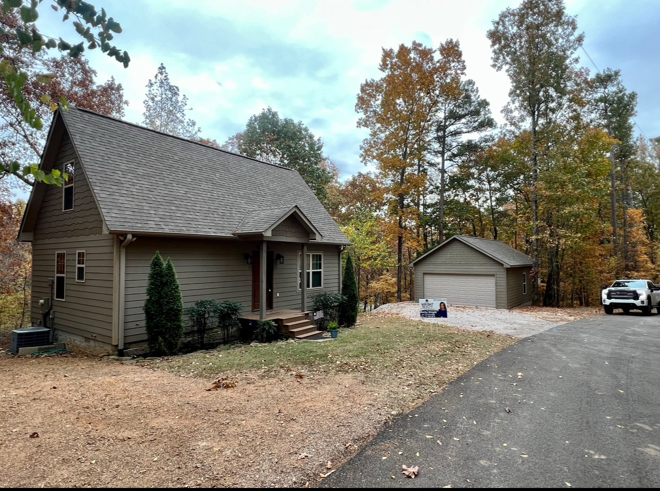Craftsman-style home with shake gables, a covered front porch and a matching detached two-car garage