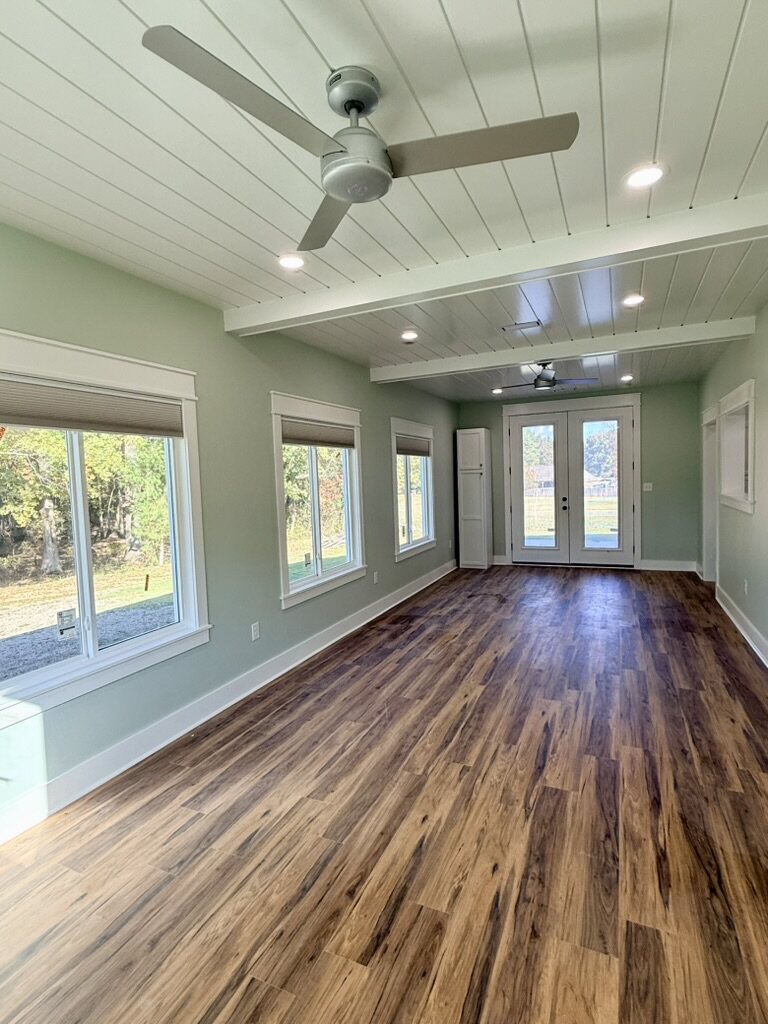 Bright room with a beamed shiplap ceiling and French doors