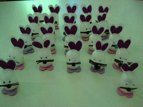 Λευκά χειροποίητα κουνελάκια με μωβ αυτιά, διακοσμητικά σε λευκό φόντο.