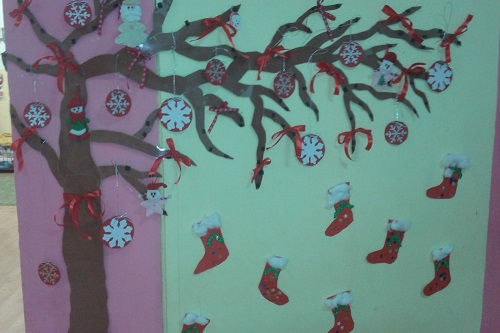 Χριστουγεννιάτικη διακόσμηση τοίχου με δέντρο, κόκκινες κάλτσες, νιφάδες, κορδέλες.