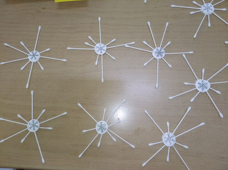 Χειροποίητες νιφάδες χιονιού από μπατονέτες σε ξύλινη επιφάνεια.