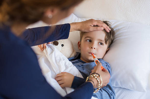 FEVER IN CHILDREN: MOTHER CHECKING FEVER BY THERMOMETER AT VELOCITY KIDS CARE