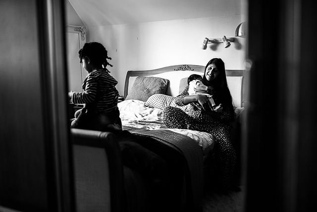 Reflection of a family bouncing on bed at an in home photography session