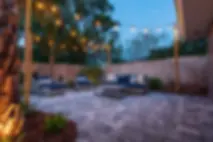 paver patio seating chairs string lighting plants.webp