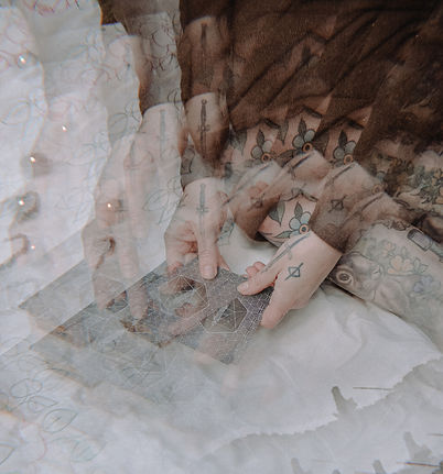A pair of hands hold tarot cards, the photo has a kaleidoscope effect on it