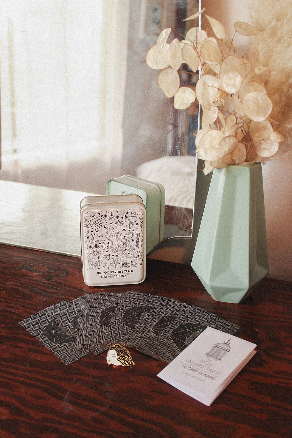 Thumbnail: Tarot cards spread out on a wicker place mat with the tin packaging arranged behind them