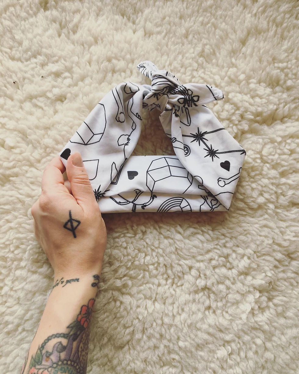 Thumbnail: An image of a folded white cloth with a black graphic pattern printed on it