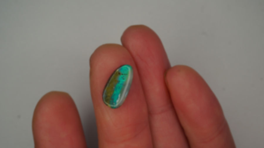 Green boulder opal with rolling green play-of-color and natural inclusions on a laurel-toned base – Australian gemstone