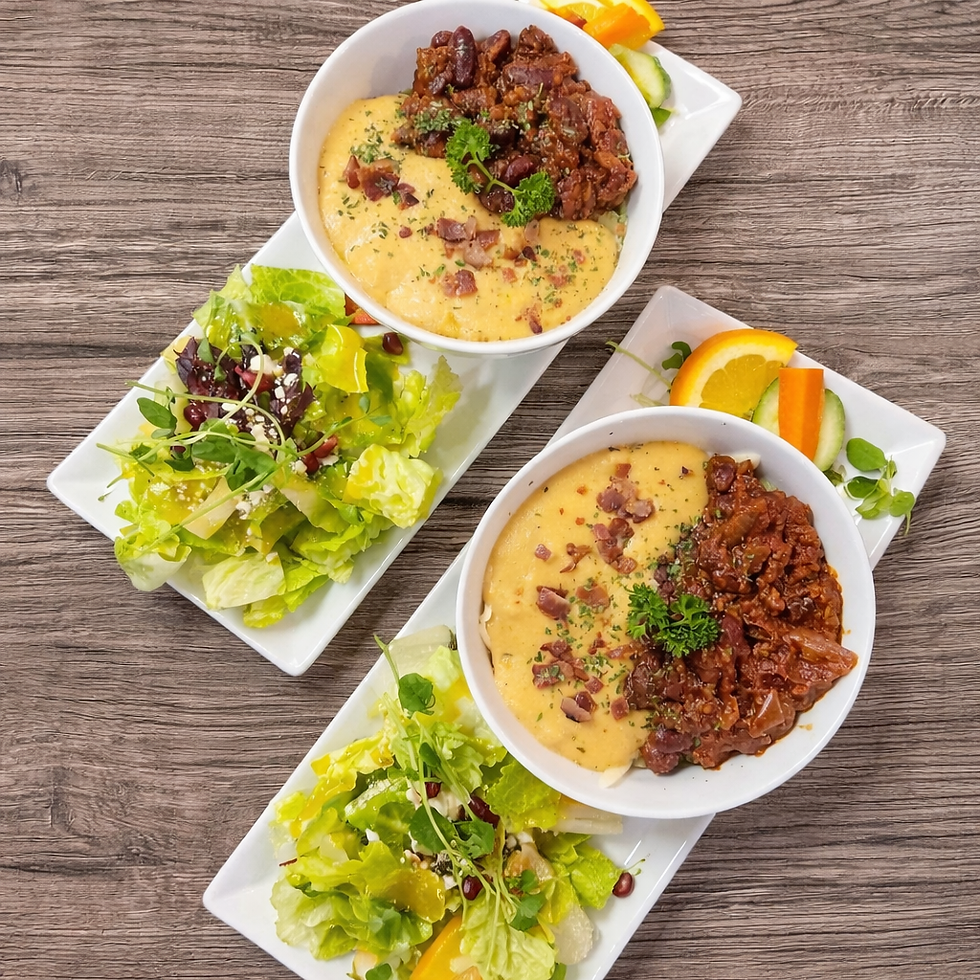 Two plates with cheesy grits, meat stew, and green salads