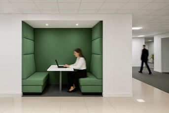 Green acoustic booth seating in Milton Keynes office breakout area, perfect for focused work.