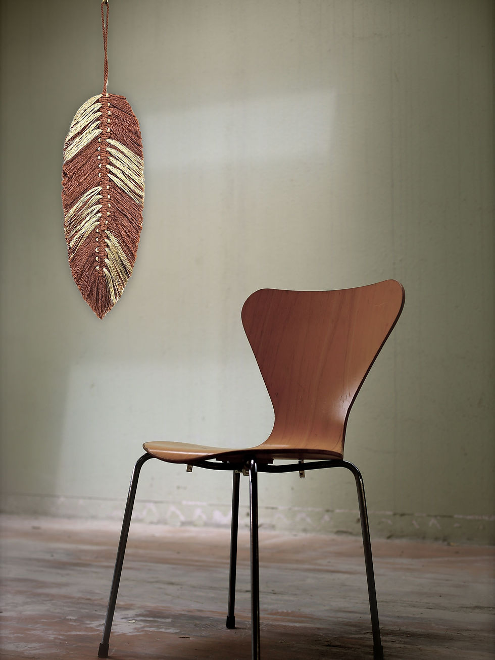 rust-gold macrame feather next to a chair