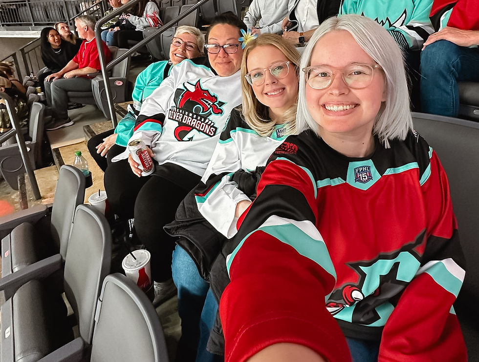 Four women wearing River Dragons jersey smile for selfie