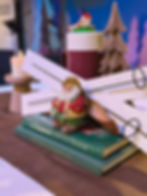 Santa figurine with books and wooden skis at a past event.