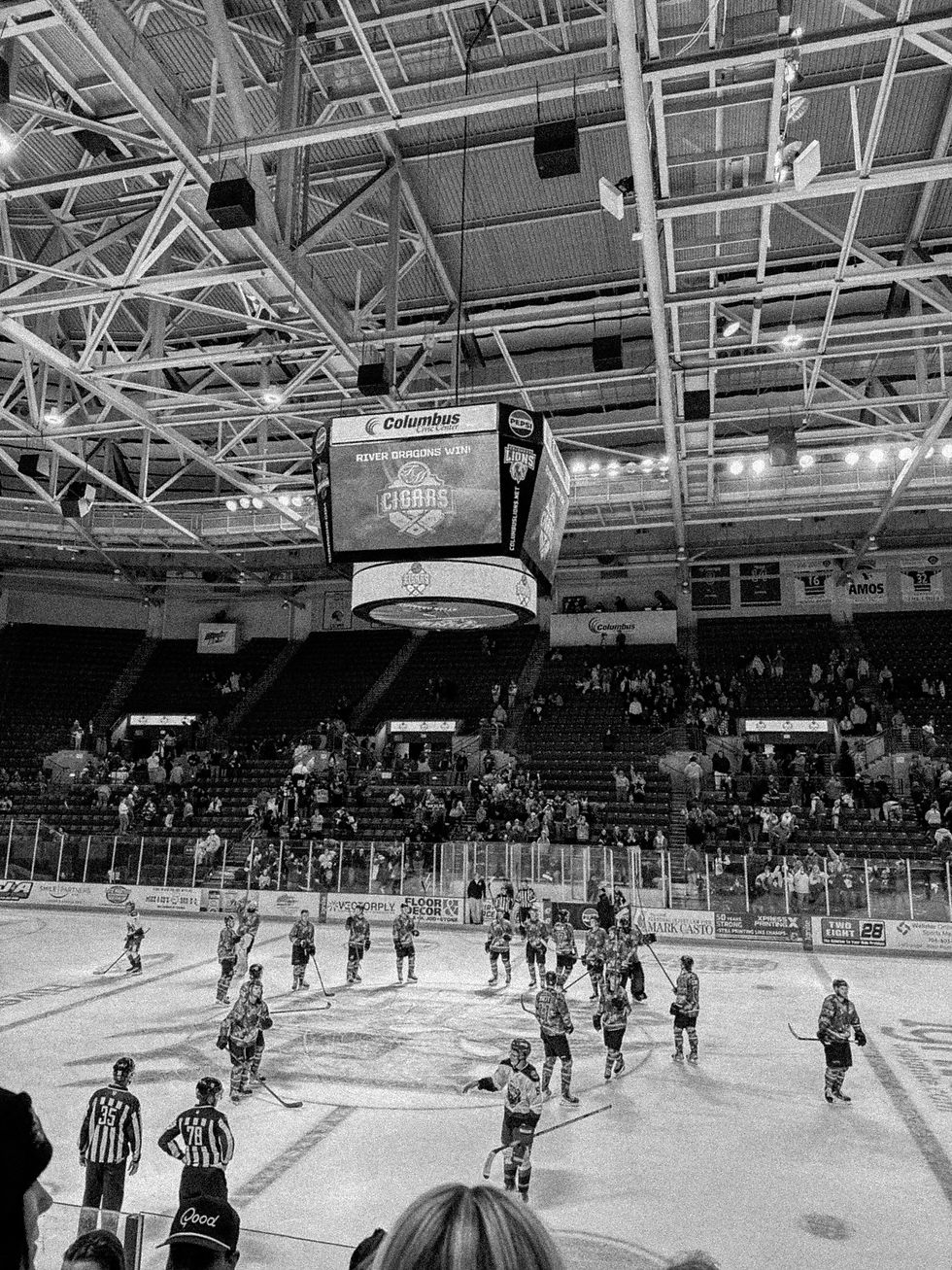 Hockey players on the ice in a crowded arena arena