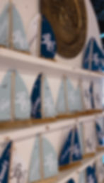 Decorative model sailboats with BC logo on shelves at a past event.