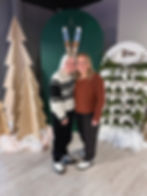 Two smiling women at a winter-themed past event.