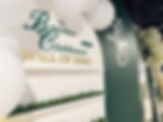 The Booster Clubhouse Wall of Fame with golf balls on turf.