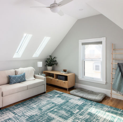 Somerville MA attic converted into living space with skylights, seating area, and hardwood floors by Morse Constructions