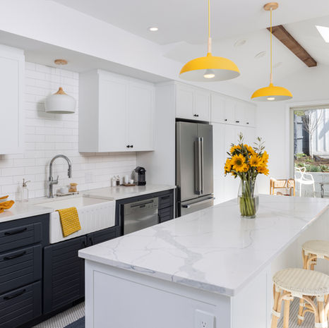 Greater Boston kitchen remodel with white island, dark lower cabinets, pendant lighting, and skylights by Morse Constructions