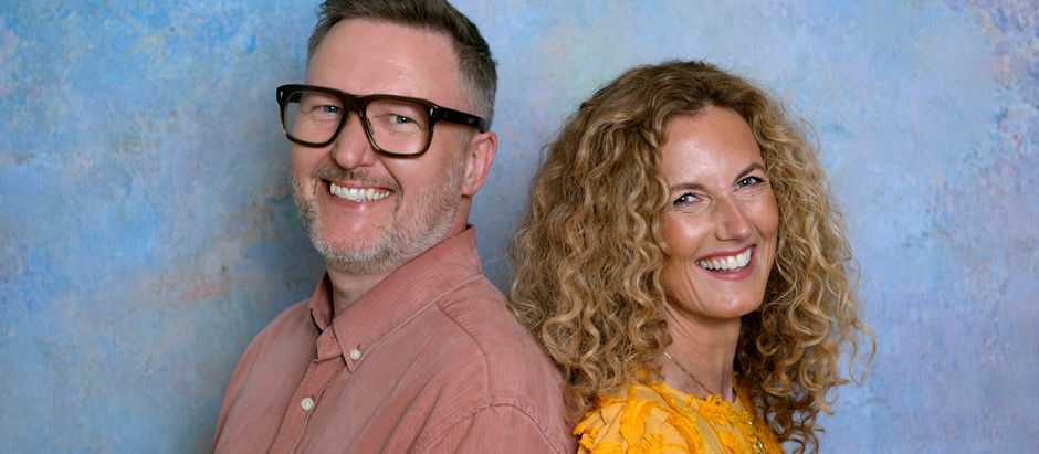 Författarna Jens Wedin och Linda Öhling står leende rygg mot rygg